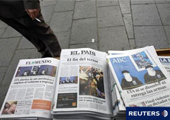 Un hombre junto a las portadas de periódicos con la noticia de ETA