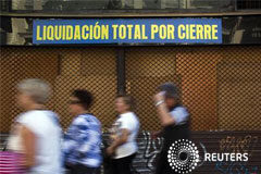 La rentabilidad del bono español a 10 años se acerca al 7,0% En la imagen unas personas pasan junto a una tienda cerrada que inició su actividad en 1934