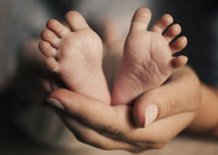 Unos pies de bebe sobre una mano