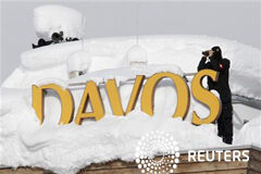 La atención gira al crecimiento tras amainar la crisis del euro Un miembro de la policía especial suiza vigila desde el tejado de un hotel cubiuerto por la nieve en Davos, el 24 de enero de 2012