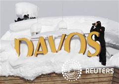 Un miembro de la policía especial suiza vigila desde el tejado de un hotel cubiuerto por la nieve en Davos, el 24 de enero de 2012