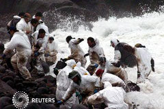 PREVIA-El vertido del Prestige va a juicio 10 años después voluntarios limpiando la costa cuando les alcanza una ola en la playa de Cuño, en la provincia de La Coruña, en febrero de 2003