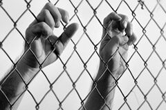 La constitucionalidad de la prisión permanente revisable Unas manos agarrando una alambrada