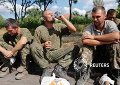 Prisioneros capturados por los separatistas sentados mientras se les asigna la limpieza de una calle en Snizhne (Snezhnoye), en la región de Donetsk, el 29 de agosto de 2014