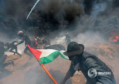 Manifestantes palestinios huyen para escabar de disparos y gases de fuerzas isaraelíes durante una protesta contra la instalación de la embajada de Estados Unidos, en la franja de Gaza. 14 de mayo de 2018
