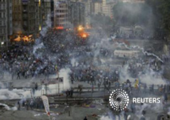 Manifestantes huyen de la policía antidisturbios en la plaza de Taksim a última hora de la tarde del 11 de junio de 2013