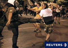Un policía antidisturbios golpea a un manifestante junto al Parlamento en Atenas