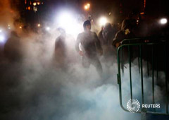 Un grupo de protestantes entre una intensa humareda frente al palacio presidencial el 8 de noviembre