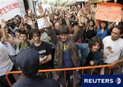 Manifestantes levantas sus brazos y gritan eslóganes frente al Parlamento valenciano el primer día de su constitución tras las elecciones del 22 de mayo, en Valencia, el 9 de junio de 2011.