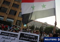 Activistas portan pancartas y banderas nacionales sirias durante una protesta en solidaridad con los manifestantes antigubernamentales sirios, en frente de la sede de la ONU y del palacio gubernamental en Beirut.