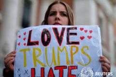 Multitudinarias protestas de mujeres contra Trump en EEUU, Asia y Europa Una mujer sostiene un letrero que muestra solidaridad con la marcha de mujeres en Washington, en Madrid, España