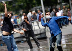 jóvenes arrojan piedras a los cañones de agua durante una protesta en la plaza de Kizilay, en el centro de Ankara, el 16 de junio de 2013.