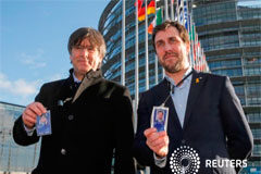 Puigdemont y Comín toman su escaño de eurodiputados Los exmiembros del Gobierno catalán Carles Puigdemont y Toni Comín muestran sus insignias a su llegada para asistir a su primera sesión plenaria como miembros del Parlamento Europeo en Estrasburgo, Francia, el 13 de enero de 2020.