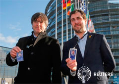 Los exmiembros del Gobierno catalán Carles Puigdemont y Toni Comín muestran sus insignias a su llegada para asistir a su primera sesión plenaria como miembros del Parlamento Europeo en Estrasburgo, Francia, el 13 de enero de 2020.