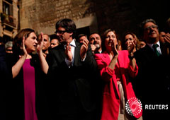 Puigdemont junto a la alcaldesa de Barcelona, Ada Colau (D), y la presidenta del Parlament, Carme Forcadell, y el delegado del Gobierno en Cataluña, Enric Milló (D), el 24 de septiembre en Barcelona