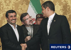 El presidente de Ecuador, Rafael Correa (dcha.) estrecha la mano de Ahmadineyad ante un intérprete durante una rueda de prensa conjunta en el Palacio Carondelet tras su encuentro en Quito