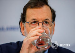 El presidente del gobierno español, Mariano Rajoy, bebe aga durante un encuentro con miembros del PP en su sede madrileña el 15 de enero