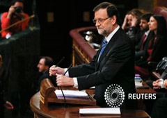 Rajoy ajusta los micrófonos en el podio antes del inicio del debate en el Congreso de los Diputados en Madrid el 24 de febrero de 2015
