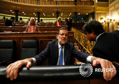 El presidente del Gobierno en funciones, Mariano Rajoy (I), habla con el jefe de su Gabinete, Jorge Moragas, en el Congreso de los Diputados en Madrid, el 25 de agosto de 2015
