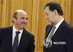 Mariano Rajoy (D), habla con el ministro de Economía, Luis de Guindos, durante la toma de posesión del nuevo gobernador del Banco de España