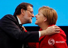 La canciller alemana Angela Merkel (i) saluda al mandatario español, Mariano Rajoy, durante la celebración de un congreso del PP Europeo en Madrid