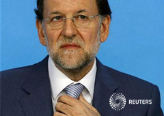 Rajoy se ajusta la corbata el 3 de septiembre de 2012 en la sede del PP en Madrid