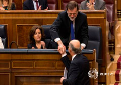 El presidente del Gobierno, Mariano Rajoy (arriba), saluda al ministro de Hacienda, Cristóbal Montoro, ante la mirada de la vicepresidenta del Gobierno, Soraya Sáenz de Santamaría (I), en el Congreso de los Diputados en Madrid, el 3 de mayo de 2017