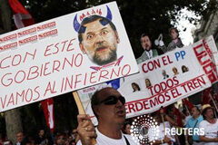 La popularidad de Rajoy cae mucho más tras los últimos recortes Un hombre sostiene una pancarta que representa a Rajoy como un diablo, durante una protesta contra las medidas de austeridad en el centro de Madrid