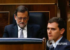 Líder del partido Ciudadanos Albert Rivera pasa junto al líder del partido, Mariano Rajoy, durante un debate de investidura en el Parlamento de Madrid, España, en este mes de marzo