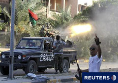 Combatientes rebeldes disparan durante enfrentamientos con fuerzas pro-Gadafi en el distrito de Abu Salim de Trípoli