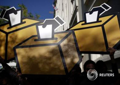 unos carteles con forma de urna en una protesta cerca del Congreso en Madrid