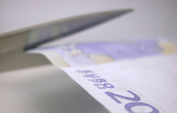 Un tijeretazo por donde más duele Una tijera cortando un billete de 20 euros