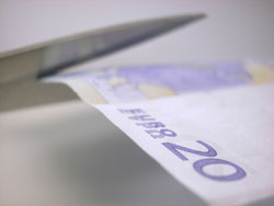 Una tijera cortando un billete de 20 euros