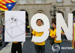 Separatistas en Cataluña con carteles en favor de la consulta, delante del Palau de la Generalitat antes de que el presidente del Gobierno catalán Artur Mas firmara un decreto pidiendo la votación, en Barcelona, el 27 de septiembre de 2014