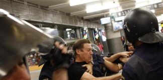 Retenciones en Madrid y Barcelona por paros en el metro y Renfe Un policía antidisturbios detiene a un miembro de un piquete en Atocha