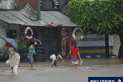 Las tormentas dejan 22 muertos en México y Centroamérica Residentes cruzan una calle inundada por las intensas lluvias