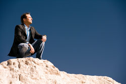 Un hombre en una roca pensando.