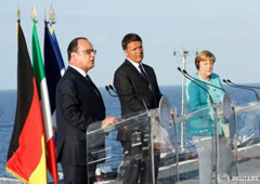 El primer ministro italiano, Matteo Renzi (centro); la canciller alemana, Angela Merkel (derecha); y el presidente francés, Francois Hollande (izquierda) durante una conferencia de prensa a bordo del portaaviones italiano Garibaldi en la costa de la isla