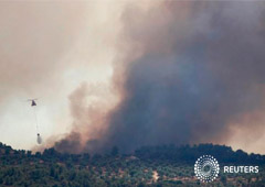 Un helicóptero deja caer agua durante un incendio forestal cerca de Bovera, Tarragona, España. 27 de junio de 2019.