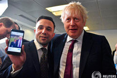 Boris Johnson dice que sería difícil tumbarse frente a las excavadoras en Heathrow El primer ministro de Reino Unido, Boris Johnson, muestra una fotografía en el teléfono de un simpatizante que posa para una foto mucho antes en el Centro de Llamadas de la Sede de la Campaña Conservadora en el centro de Londres, Reino Unido, el 8 de dici