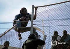 Inmigrantes africanos tratan de saltar la valla entre Marruecos y España en Melilla, 21 de noviembre de 2015