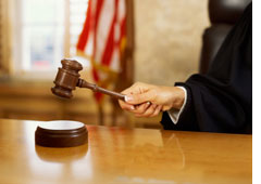Un juez usando la maza en un juicio.