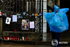 Santiago se prepara para un funeral oficial por las víctimas del tren Un hombre se protege de la lluvia junto a un altar improvisado con velas, mensajes y flores en memoria de las víctimas del tren en el exterior de la catedral de Santiago de Compostela, el 27 de julio de 2013