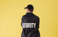 La defensa de la competencia y los convenios colectivos Hombre de seguridad sobre fondo amarillo