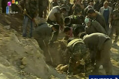 Los sirios huyen del avance militar en el norte En la imagen de vídeo tomada el 12 de junio, unos hombres recuperan los cadáveres de 10 miembros de las fuerzas de seguridad asesinados y enterrados por grupos armados en Jisr al-Shughur, según la agencia siria de noticias.