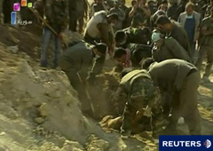 En la imagen de vídeo tomada el 12 de junio, unos hombres recuperan los cadáveres de 10 miembros de las fuerzas de seguridad asesinados y enterrados por grupos armados en Jisr al-Shughur, según la agencia siria de noticias.