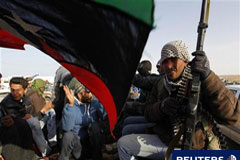 Los rebeldes libios dicen capturar la ciudad natal de Gadafi Un combatiente rebelde mira mientras varias personas celebran la retirada de las fuerzas de Gadafi cerca de Ras Lanuf, el 27 de marzo de 2011.