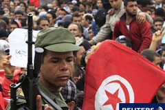 Túnez declara tres días de duelo nacional por las víctimas Un soldado tunecino hace guardia frente a la sede del partido RCD del derrocado presidente Zine al-Abidine Ben Ali durante una manifestación en el centro de Túnez