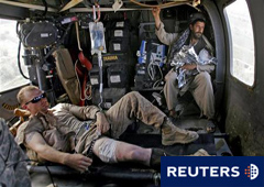 Imagen del 21 de agosto que muestra a un marine herido por la exlosión de un dispositivo improvisado y a un afgano que lleva a su hija herida de bala, siendo transportados a un hospital militar en un helicóptero medicalizado, cerca del pueblo de Marjah, e