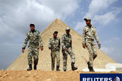 El Gobierno egipcio resiste la presión creciente por el cambio Varios soldados egipcios pasan junto a las pirámides de Giza, en El Cairo, el 9 de febrero de 2011.